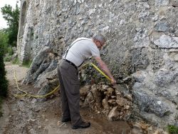 Jean-Paul M. nettoie le soubassement du mur