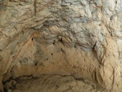 Le fond de la grotte couvert de trous de barres à mine du XVIIe siècle