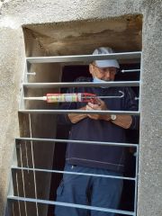 Jean-Jacques fixe trois nouveaux barreaux pour protéger la fenêtre sud